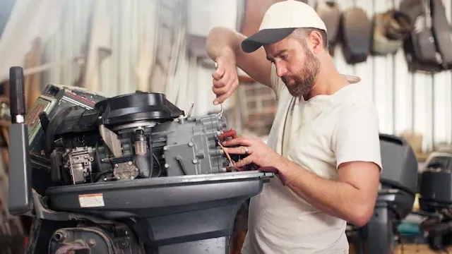 Mechanic performing maintenance on an outboard motor